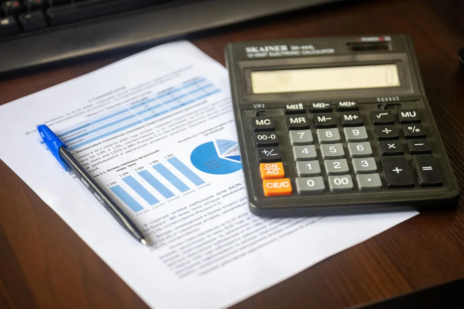 Calculator, pen and financial documents on a desk – illustrative image for checking payments
