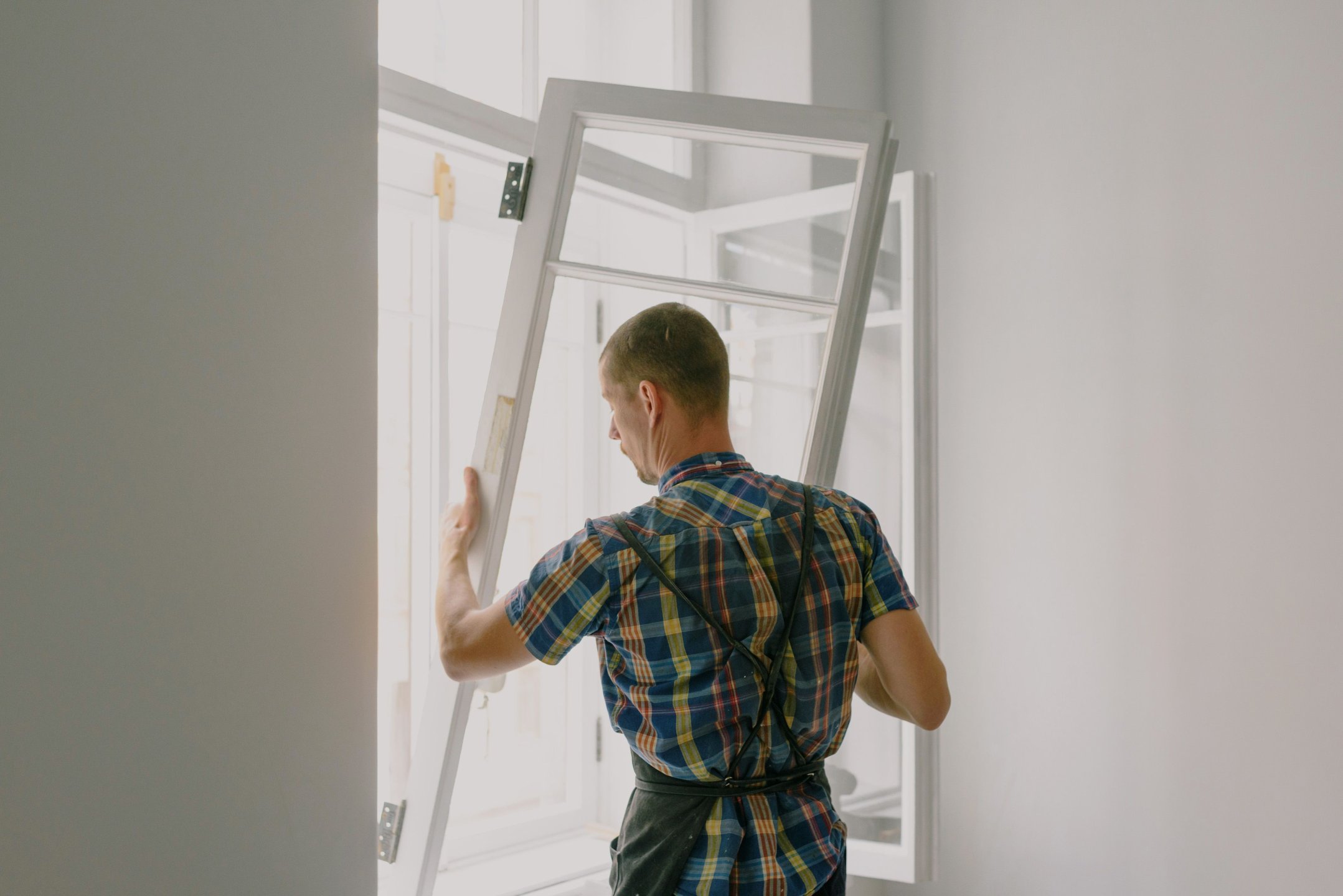 Fensterbauer montiert ein neues Fenster auf einer Baustelle