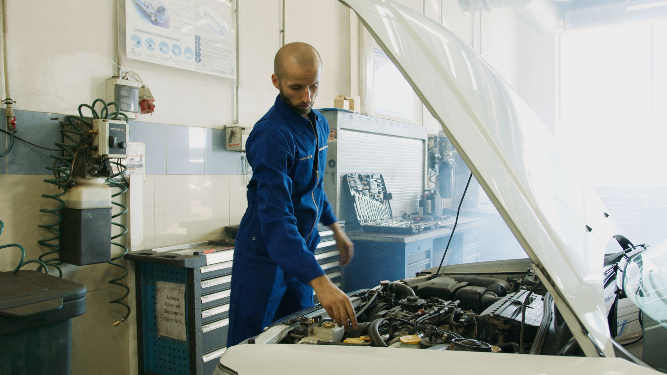 Kfz-Mechaniker prüft einen Motor in der Werkstatt